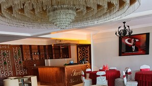 Un vestíbulo de hotel con mostrador de recepción, zonas de estar y un candelabro.