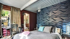 A bedroom with a bed, a desk, and a chair.