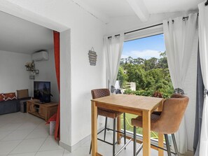 A modern living room with a TV, sofa, and a dining area with a table and chairs. - Hameau de Croisette Plage by Interhome (Sainte Maxime)