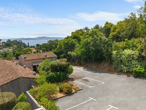 Um estacionamento com vista para a área costeira, cercado por vegetação e edifícios.