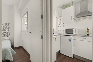 A compact kitchen with a microwave, stove, and cabinets.