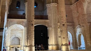 An interior with high stone columns, arched ceilings, and a central open space.
