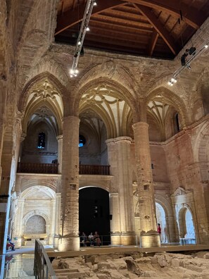 Un interior amb altes columnes de pedra, sostres en arc i un espai central obert.