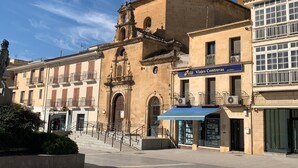 A historic building with a bell tower, a blue awning, and a sign for 'Viajes Conteras.'