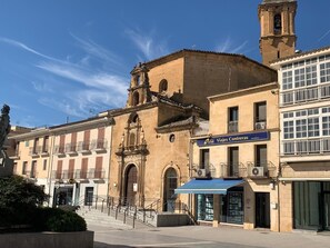 Edifici històric amb una torre del campanar, una tenda blava i un cartell de 'Viajes Conteras'.