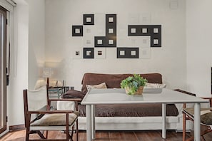 En moderne stue med en hvid sofa, et sofabord og en vægmonteret lampe.