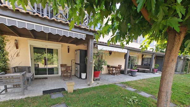 A covered outdoor patio with a table and chairs, a grill, and potted plants. - Near Bordeaux: air conditioning, parking, and a picturesque setting (Latresne)