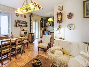 A cozy living room with a dining table, chairs, a sofa, and a kitchen in the background. - Cà Olivella by Interhome (Casarza Ligure)