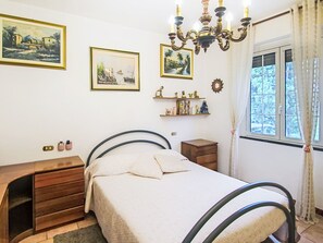 A bedroom with a bed, dresser, and two paintings on the wall. - Cà Olivella by Interhome (Casarza Ligure)