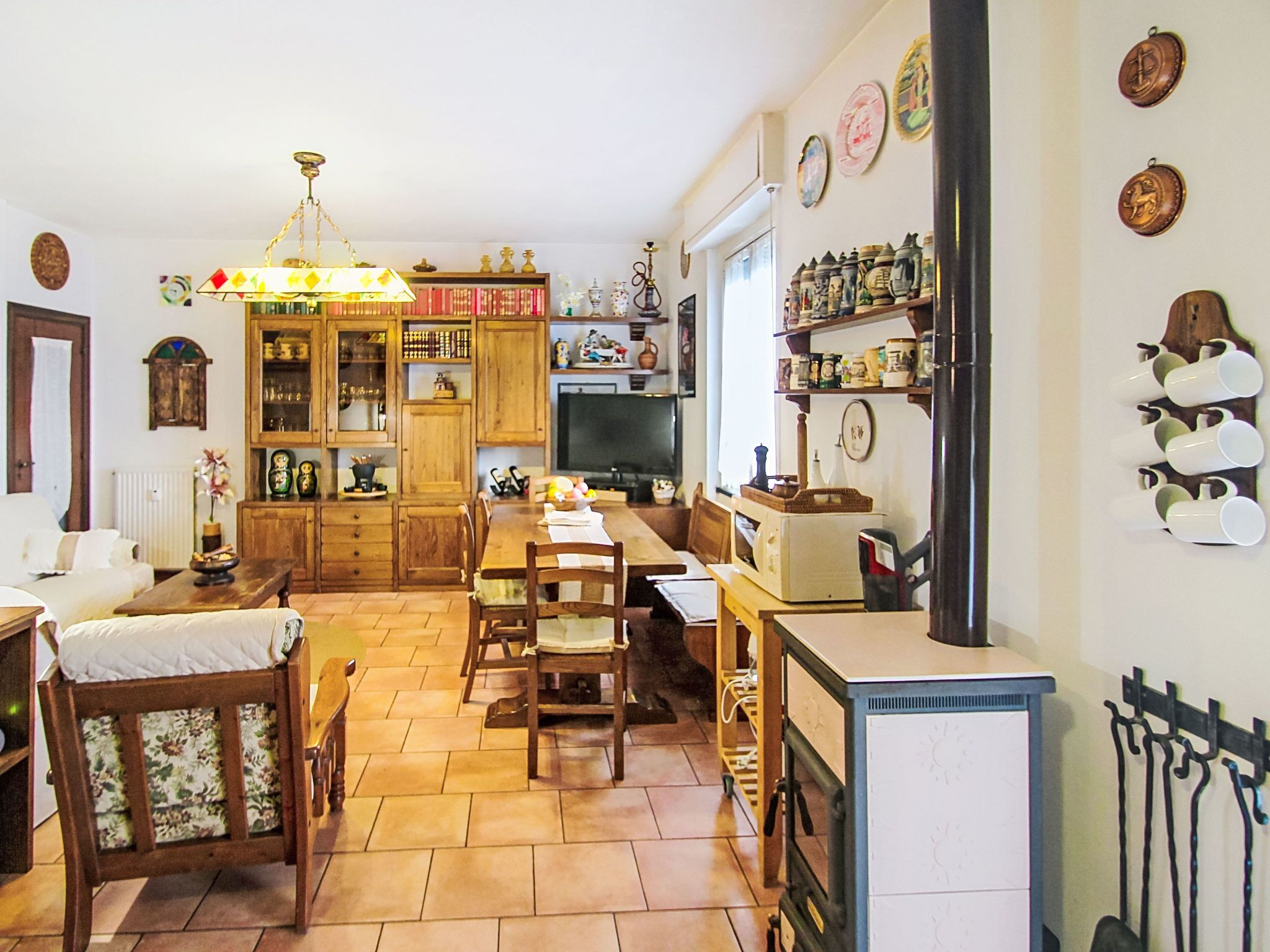 Una cocina acogedora con armarios de madera, una mesa de comedor, sillas y un refrigerador.