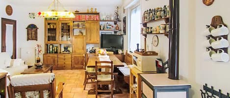 Una cocina acogedora con armarios de madera, una mesa de comedor, sillas y un refrigerador.