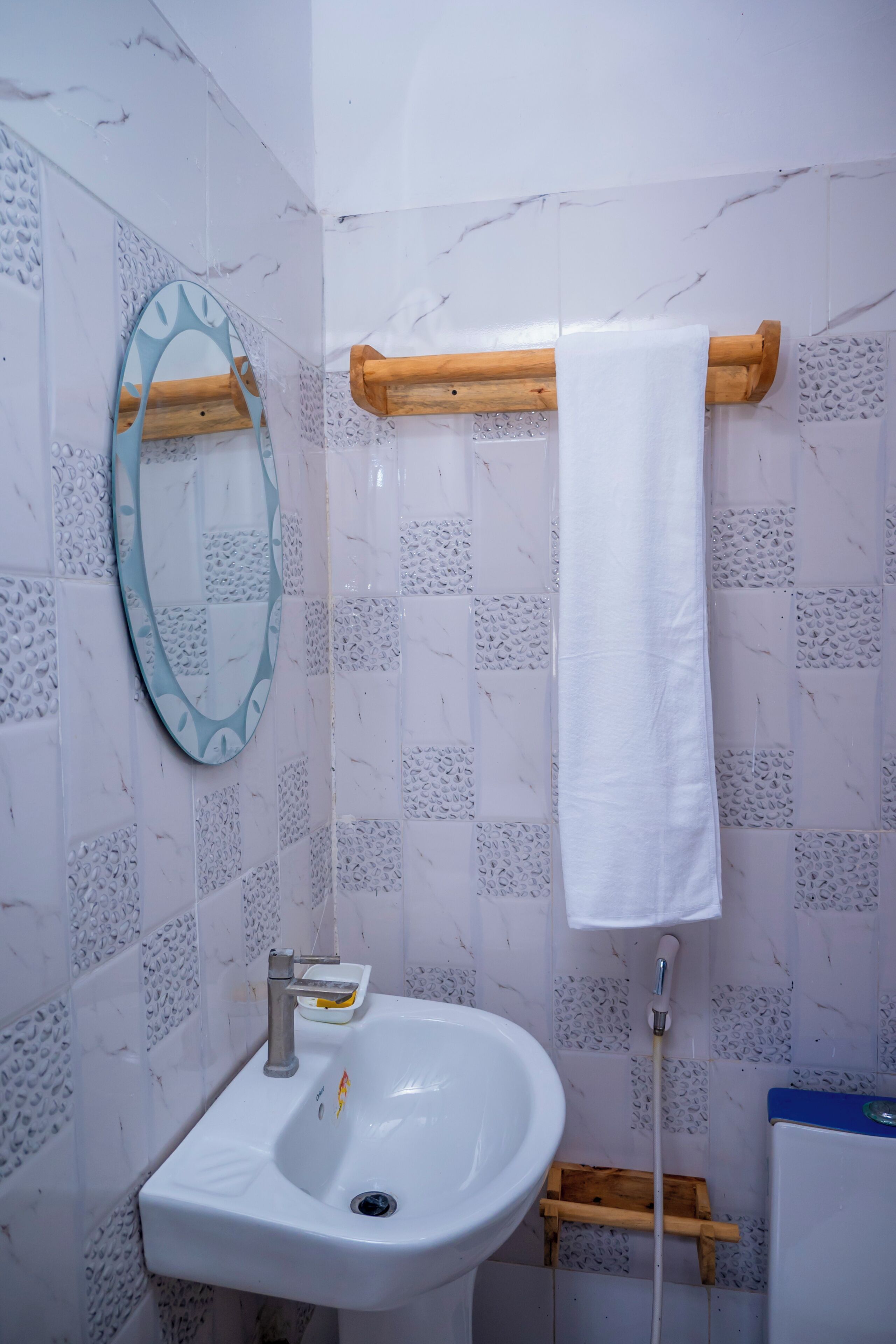 Een badkamer met een wastafel, spiegel en handdoekrek.