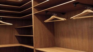 Un armario de madera con varias repisas y perchas de madera.