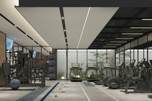 Un gimnasio moderno con diverso equipo de ejercicio, amplias ventanas y una distribución limpia y ordenada.