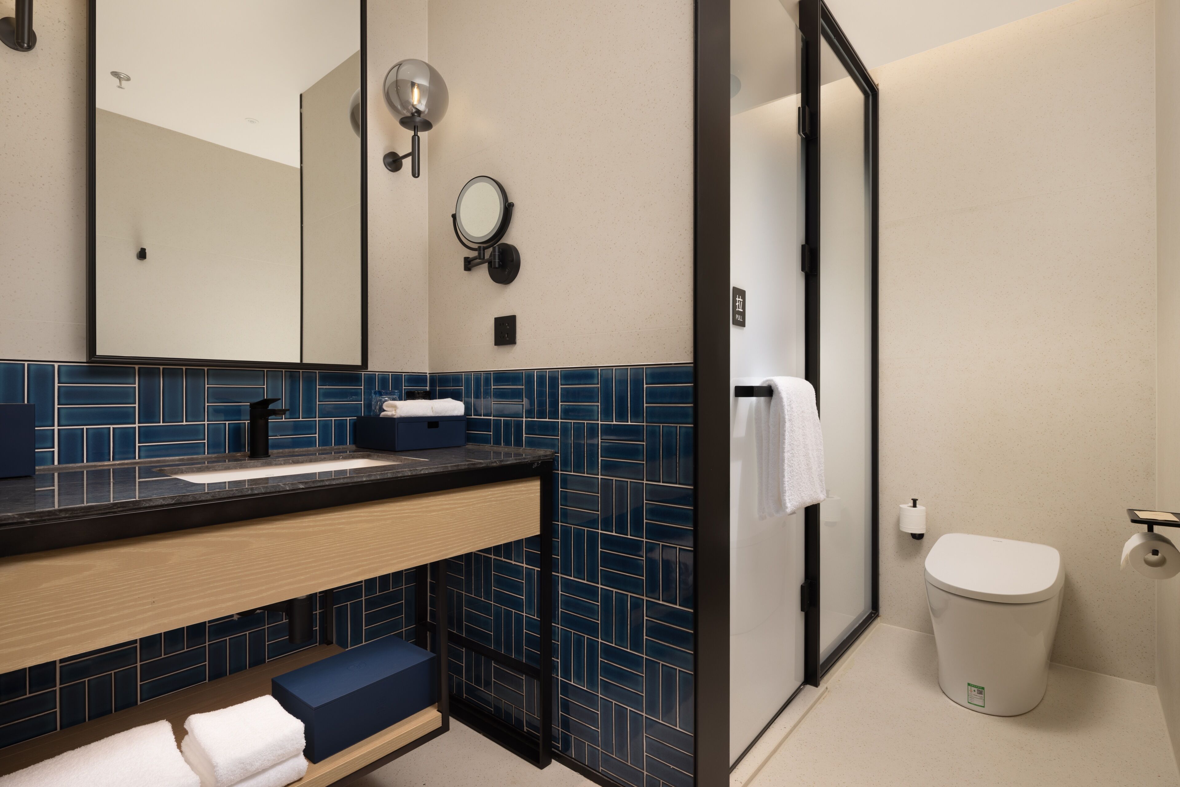 A modern bathroom with a sink, mirror, and toilet.