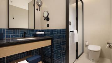 A modern bathroom with a sink, mirror, and toilet.