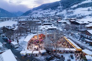 A snow-covered town with a central market area and buildings in the background.