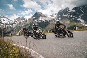 Two motorcycles parked on a road with a mountainous backdrop.