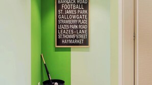 Eine Wand mit einer Liste von Straßennamen und einem schwarzen Baseballschläger, der an eine grüne Wand gelehnt ist.