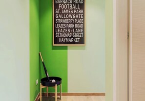 Uma parede com uma lista de nomes de ruas e um bastão de beisebol preto encostado numa parede verde.