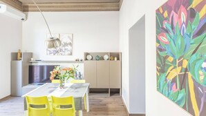 A dining area with a table, chairs, and a painting on the wall. - Indipendenza (Bologna)