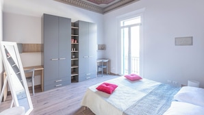 A bedroom with a bed, a desk, a wardrobe, and a large window. - Indipendenza (Bologna)