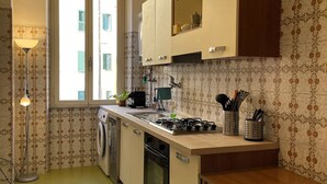 Eine kompakte Küche mit Waschmaschine, Herd und Spüle.