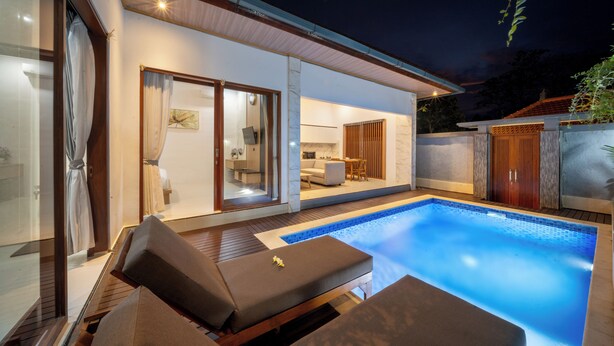 Uma casa moderna com piscina, terraço ensolarado e área de refeições.
