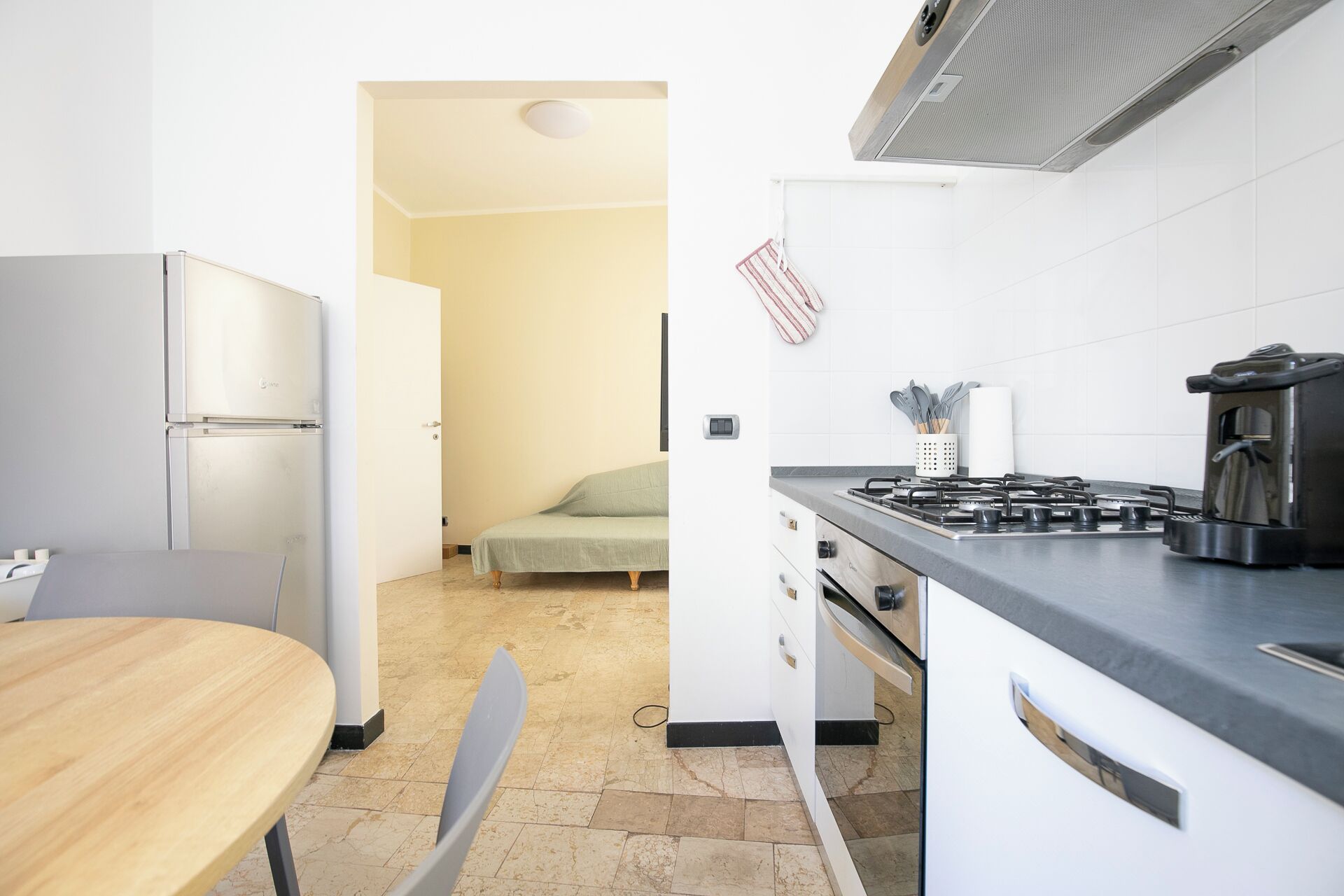 A compact kitchen with a stove, refrigerator, and dining area.