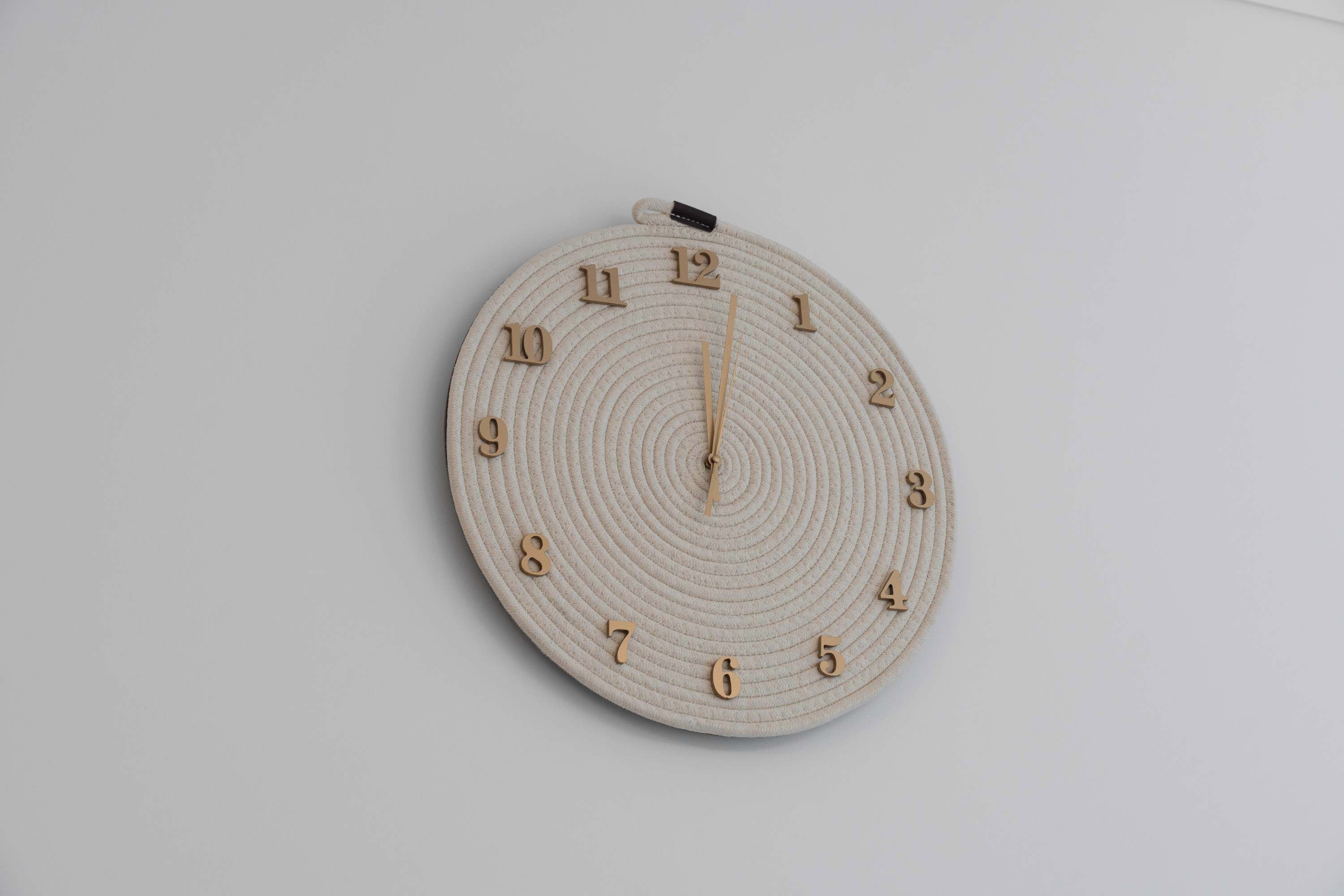 Un reloj de pared redondo con un diseño minimalista, que presenta los números del 1 al 12 y un segundero central.