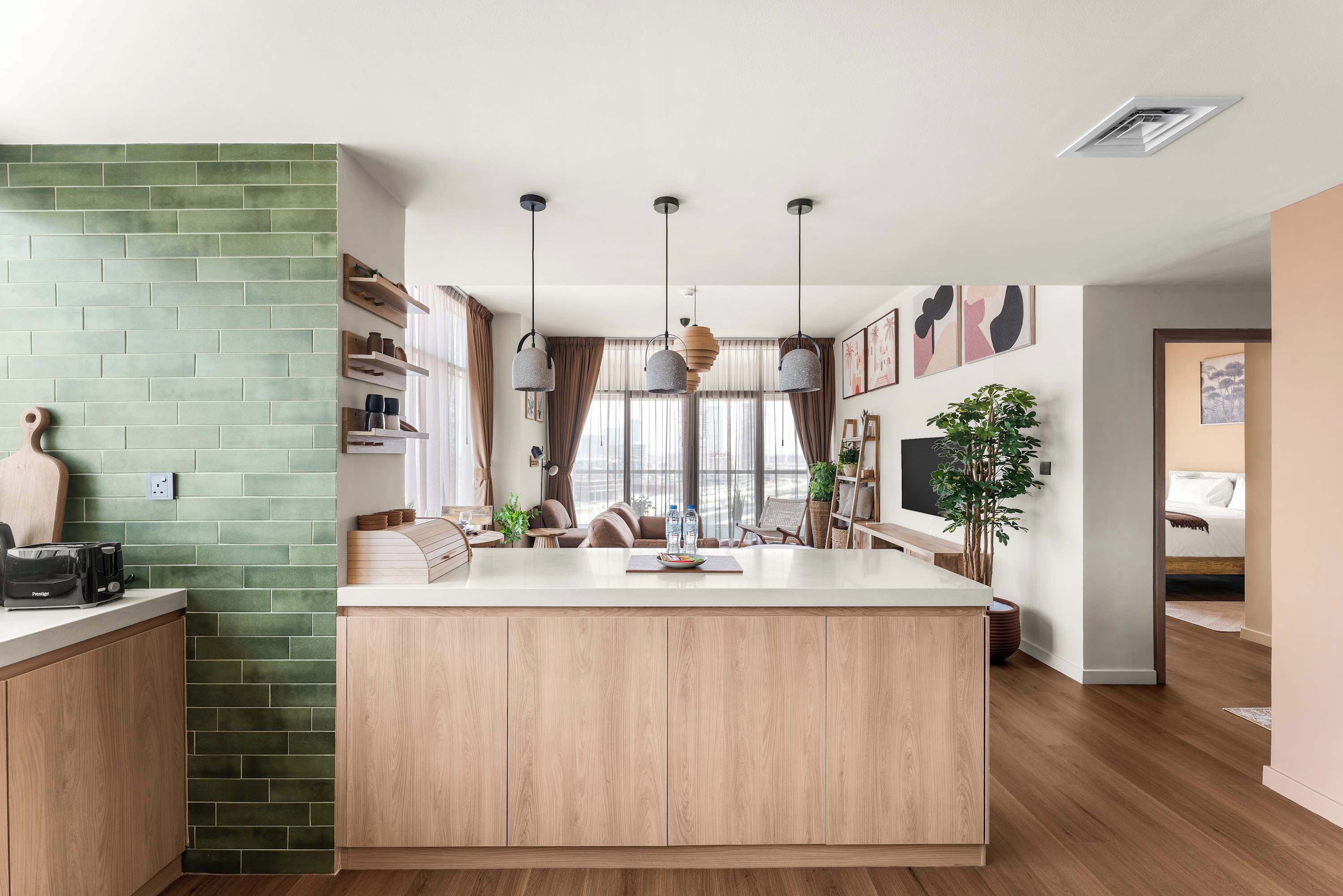 Une cuisine moderne dotée d’un îlot central, de meubles en bois et de luminaires suspendus.