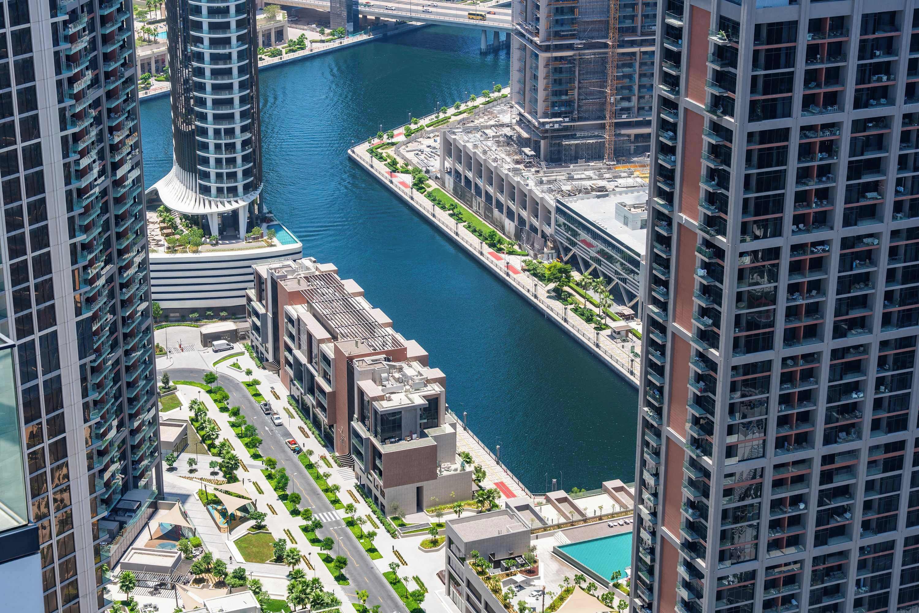 A high-rise building with a river running through the middle, surrounded by other tall buildings.