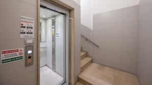 Een lift met spoedeisende instructies, een handgreep en een trap.