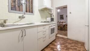 Una cucina compatta con lavello, piano cottura, forno a microonde e mobili.