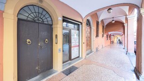 A corridor with arched ceilings, a door with a sign, and a tiled floor. - Borgo San Pietro Garden (Bologna)