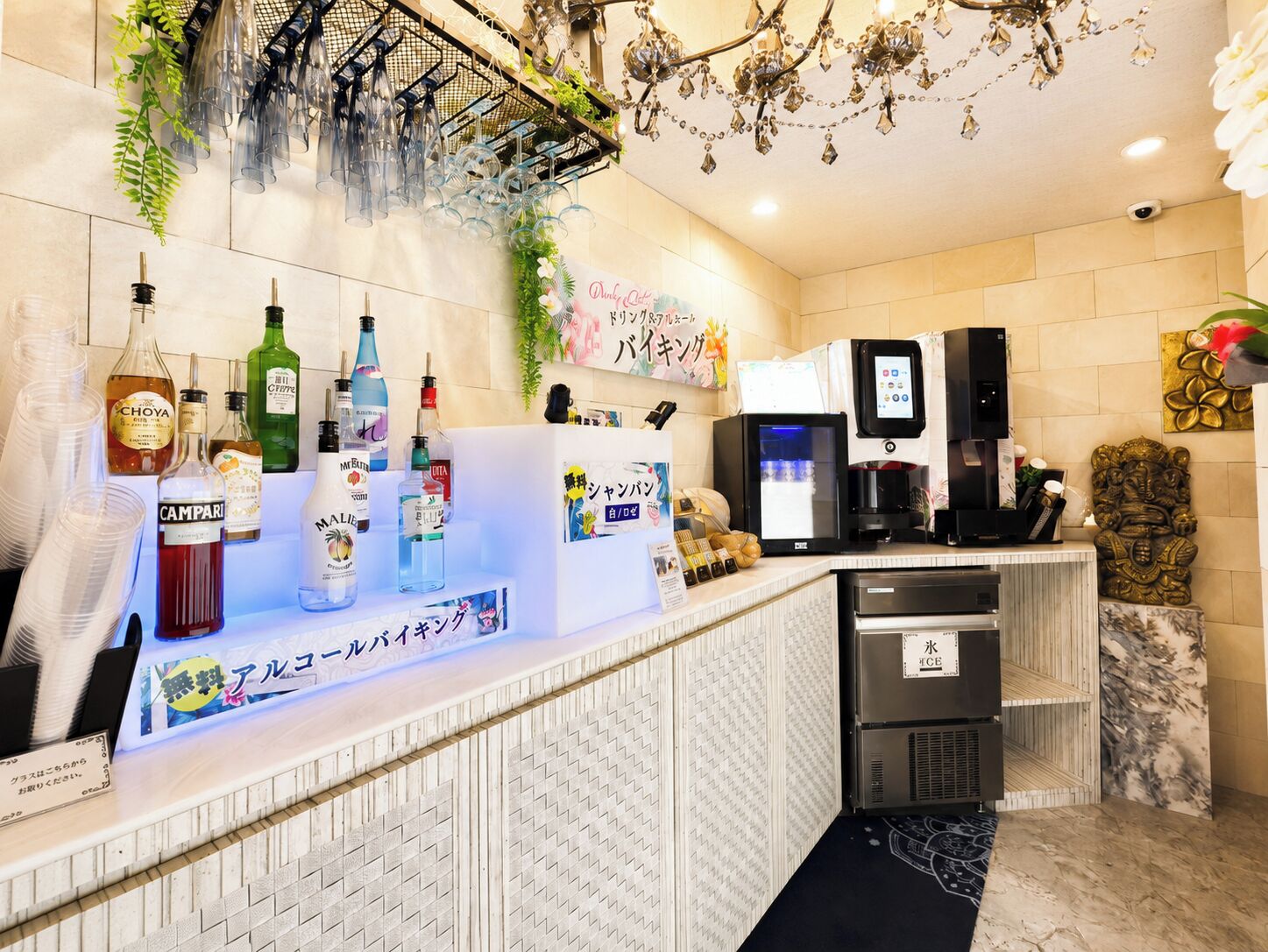 Zona de bar con mostrador que exhibe varias botellas de licores, una máquina de café y una caja registradora.