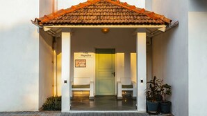 A building entrance with a tiled roof, a green door, and a sign reading 'Villa Magnifica.' - Aroha Palms Luxury Apartments (Mandrem)