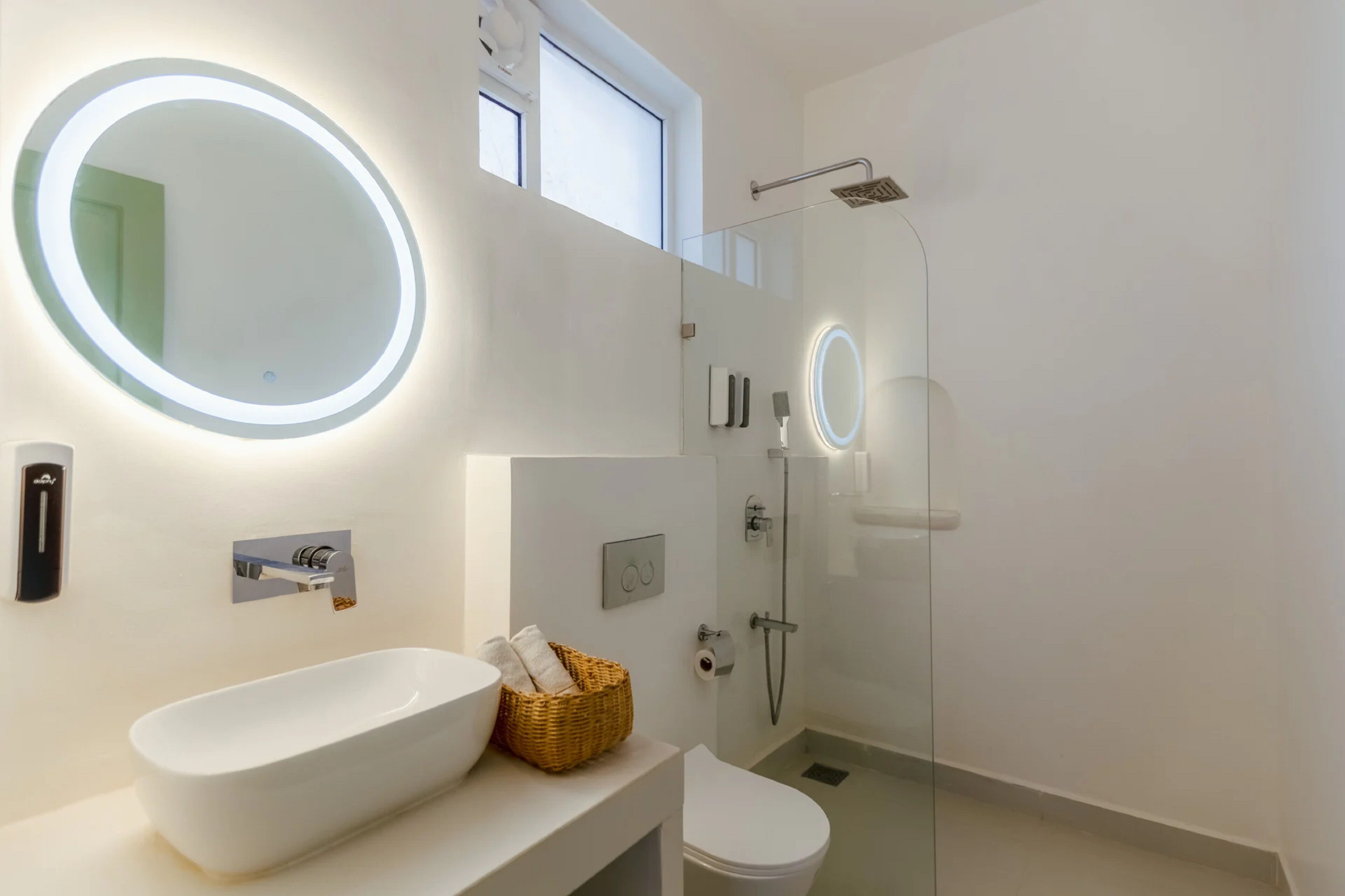 Une salle de bain moderne avec une baignoire sur pieds, un grand miroir, des toilettes et une douche à parois de verre.
