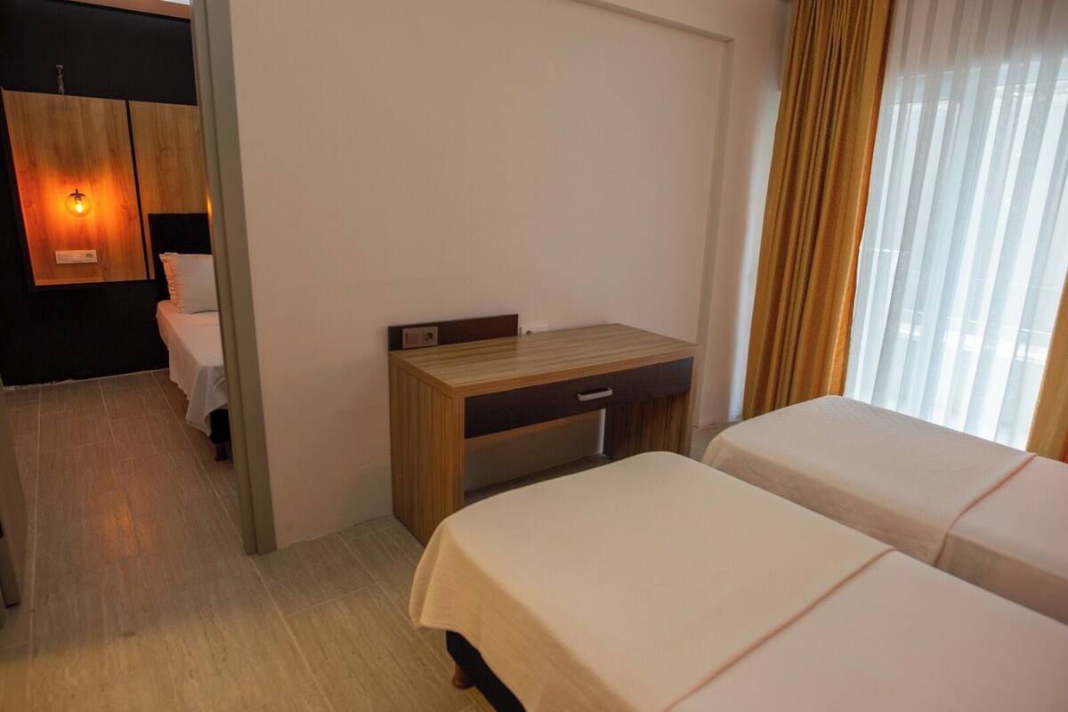 A hotel room with a bed, a desk, and a bathroom.