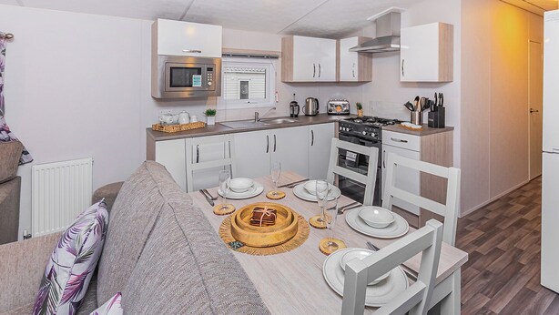 Un espacio habitable compacto con kitchenette, comedor y sofá.