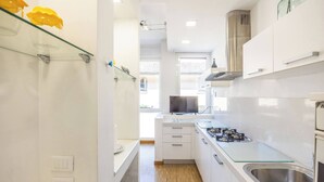 A modern kitchen with white cabinets, a stainless steel sink, and a glass countertop. - Lame Pro (Bologna)