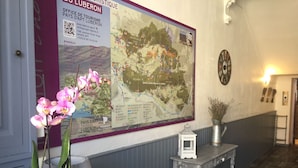 Uma área de recepção com um mapa grande, um relógio e uma pequena mesa com uma placa.