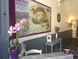 A reception area with a large map, a clock, and a small table with a sign. - luberon hotel restaurant family (Apt)