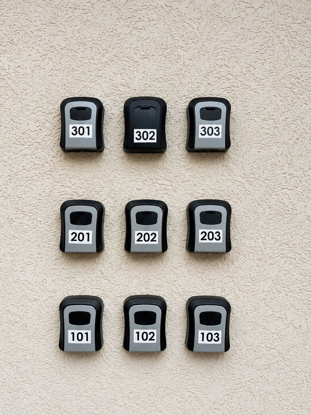 A wall with nine numbered mailboxes arranged in three rows.