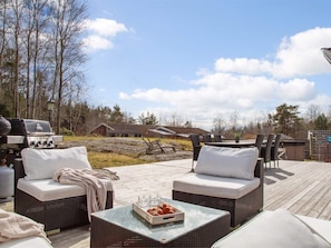 An outdoor patio with wicker furniture and a grill. - 5 Star Holiday Home in Svanesund (Svanesund)