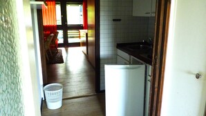 Eine kleine Küche mit Kühlschrank, Spüle und Holzboden.