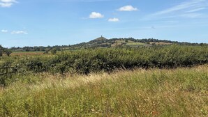 Eine ländliche Landschaft mit sanften Hügeln, blauem Himmel und einem entfernten Hügelkamm.