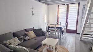 Una sala de estar con sofá, mesa de centro y comedor con sillas y una mesa.