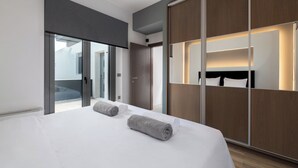 A modern hotel room with a large bed, a sliding door closet, and a view through the door. - Rosa D'oro (Maritsa)