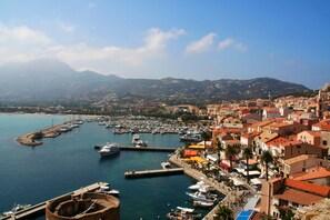 A coastal town with a marina, historic buildings, and a mountainous backdrop. - GRAPI Farm with a swim spa for 4 adults and 4 children (CALVI)